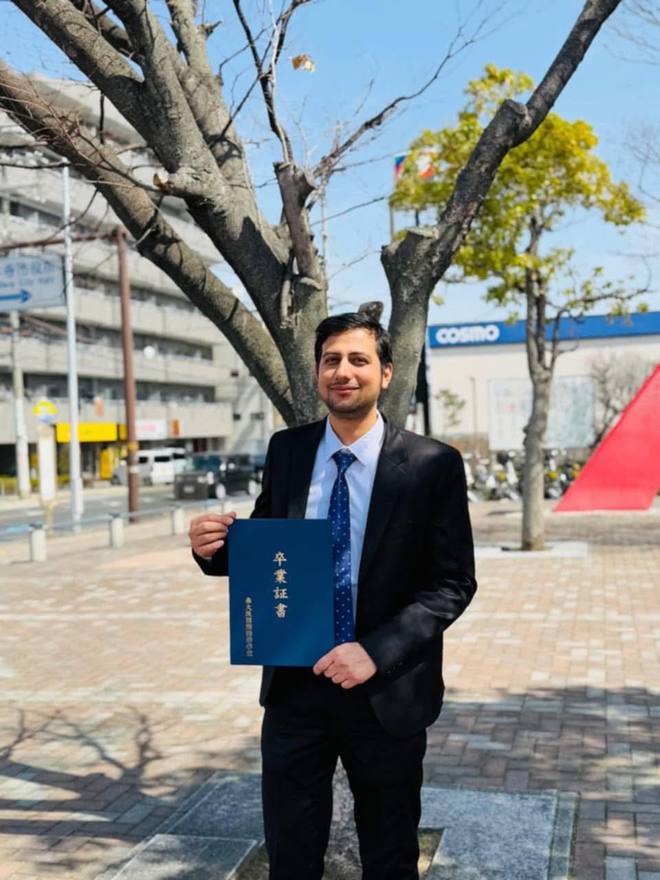 Birkausalya graduate outside his school in Japan